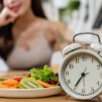 a plate of fruit and vegetables next to a clock . Intermittent Fasting for Women Over 40