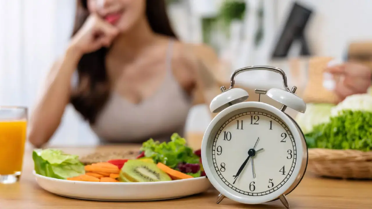 Intermittent Fasting for Women Over 40: A Safe & Effective Approach 1 a plate of fruit and vegetables next to a clock . Intermittent Fasting for Women Over 40